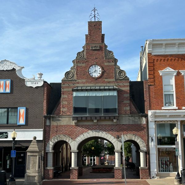 a large brick building with a clock on the side of a road