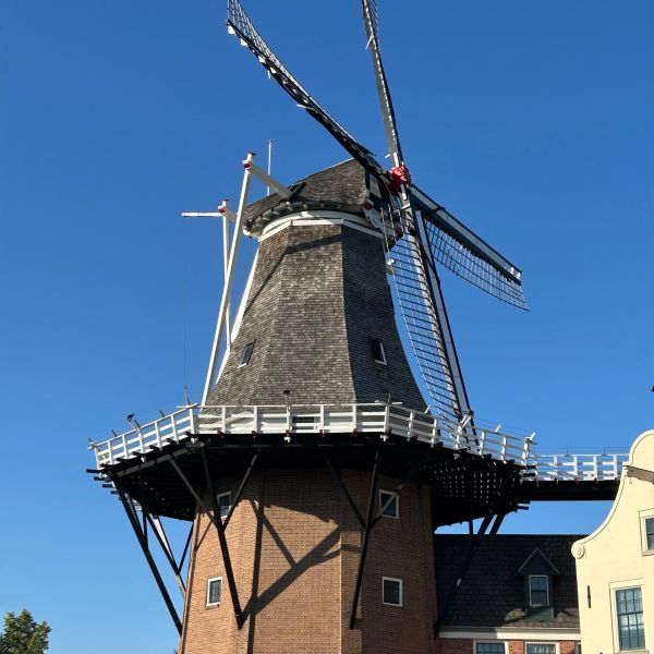 a large brick building with De Zwaan in the background